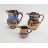 A collection of three Staffordshire copper lustre jugs with blue handmade leaf decorations, c19th