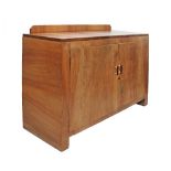 An Art Deco revival blonde walnut veneered dresser with two doors enclosing a cupboard and