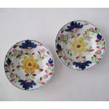 A pair of ceramic plates, D23cm, Folk Art hand painted flower decoration and blue line to the rim.