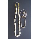 An ivory necklace L70cm together with a white metal chocker and a hallmarked silver bracelet. (3)