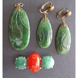 A collection of a carved green jade pendant L50mm, a pair of earrings and a pin brooch L45mm, with