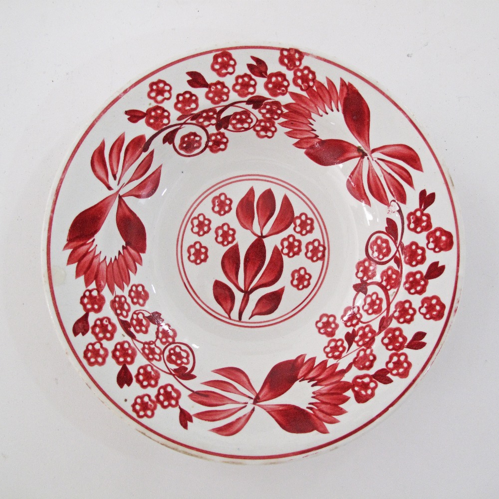 A folkloric ceramic dish hand decorated with red flowers and foliage. Impressed markings with