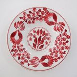 A folkloric ceramic dish hand decorated with red flowers and foliage. Impressed markings with