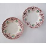 A pair of ceramic plates, D23cm, Folk Art stenciled flower garland decoration to the rim.