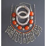 A collection of two necklaces set with amber and coral and a pair of bracelets in white metal. (4)