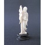 A Chinese carved ivory figure of Shou Lao the god of longevity holding in one hand a magic peach