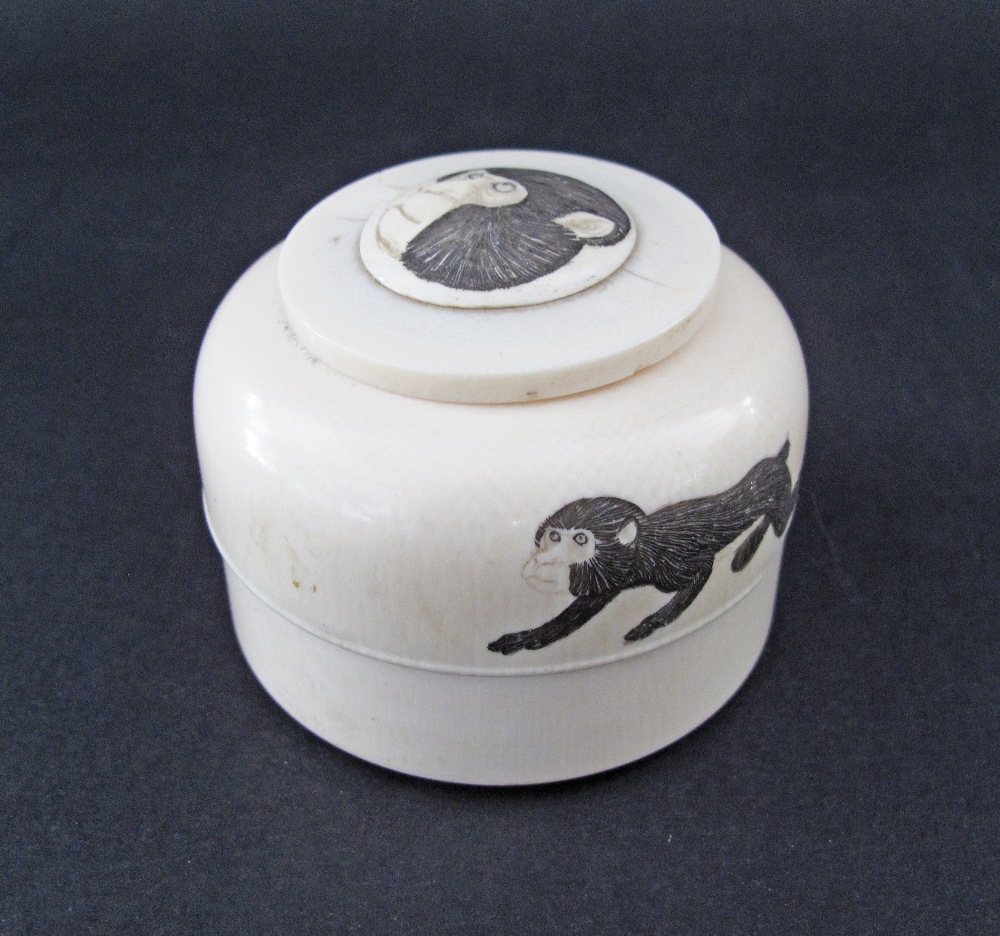 A Japanese round carved ivory scrimshaw pill box, c19th century, engraved with monkeys, weight