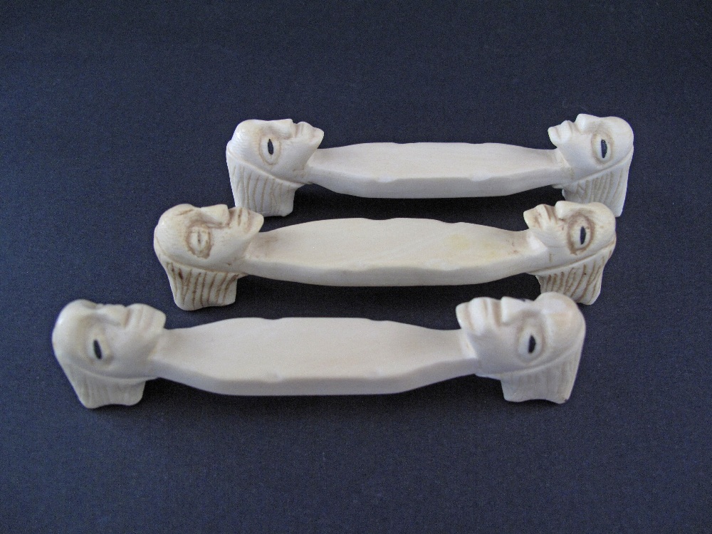 A set of three carved ivory knife rests with heads, probably African, c19th / early 20th century,