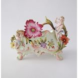 An unmarked porcelain boat probably French Samson, decorated with flowers and cherubs in relief,