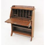 An Arts and Crafts oak bureau with drop flap above single drawer, the sloped front enclosing
