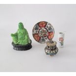 A Chinese style seated Buddha in green resin imitating jade on wooden base with pseudo markings to
