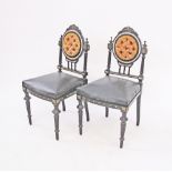 A pair of Louis XVI style side chairs, carved, ebonised and inlaid with mother of pearl