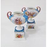 A pair of Vienna style porcelain oval twin handled footed urns