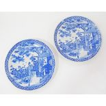 Pair of Oriental blue and white porcelain chargers printed with landscape