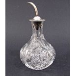 A lead crystal hand cut vinegar bottle with a sterling silver pouring cup.