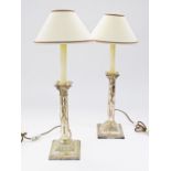 A pair of silver candle sticks converted to table lamps, worn Hallmarks. C19th century.