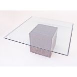 A large modern glass top and grey fiberglass cube base center table