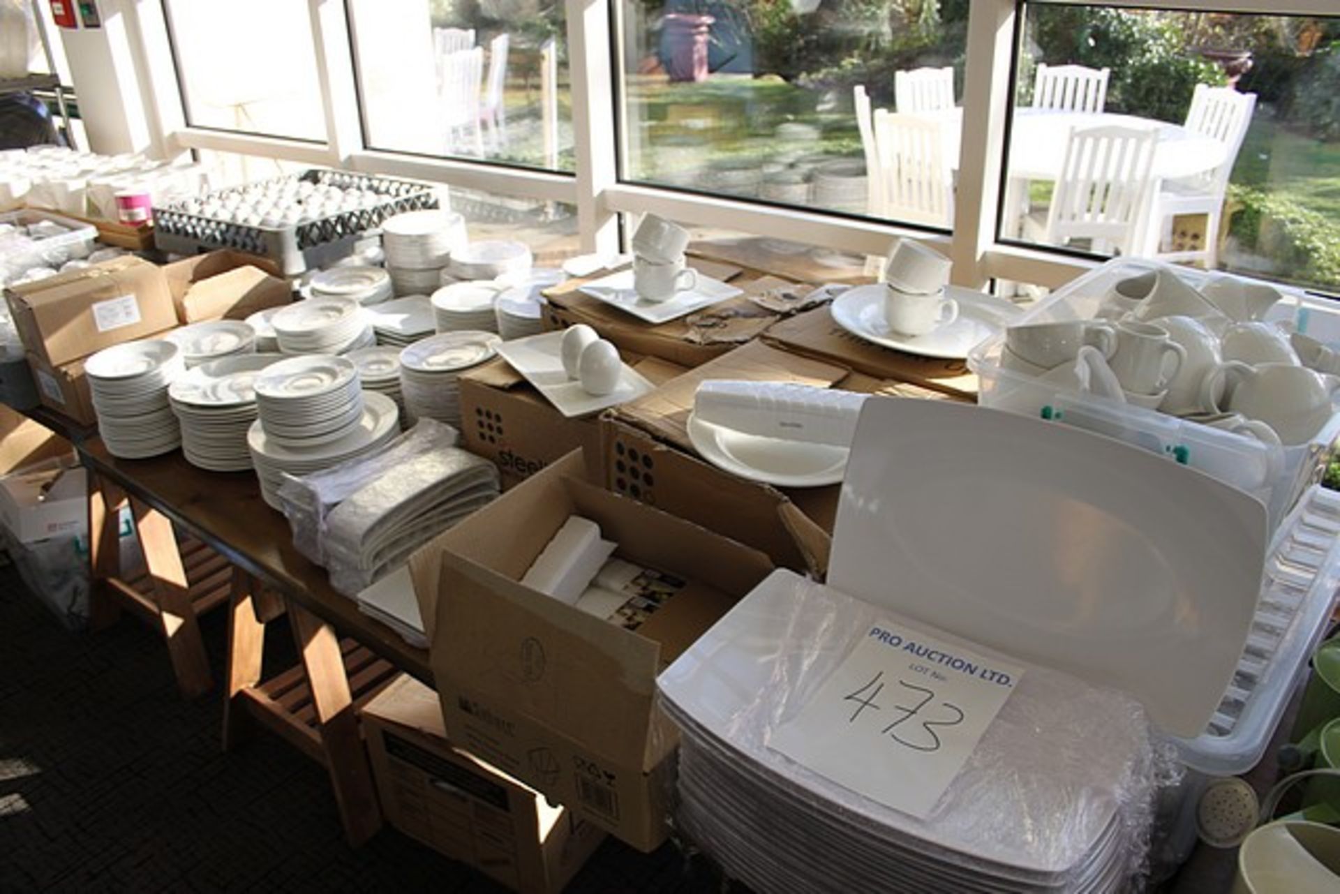 A large quantity of white tableware comprising of cups, saucers, plates, milk jugs, cruet sets,