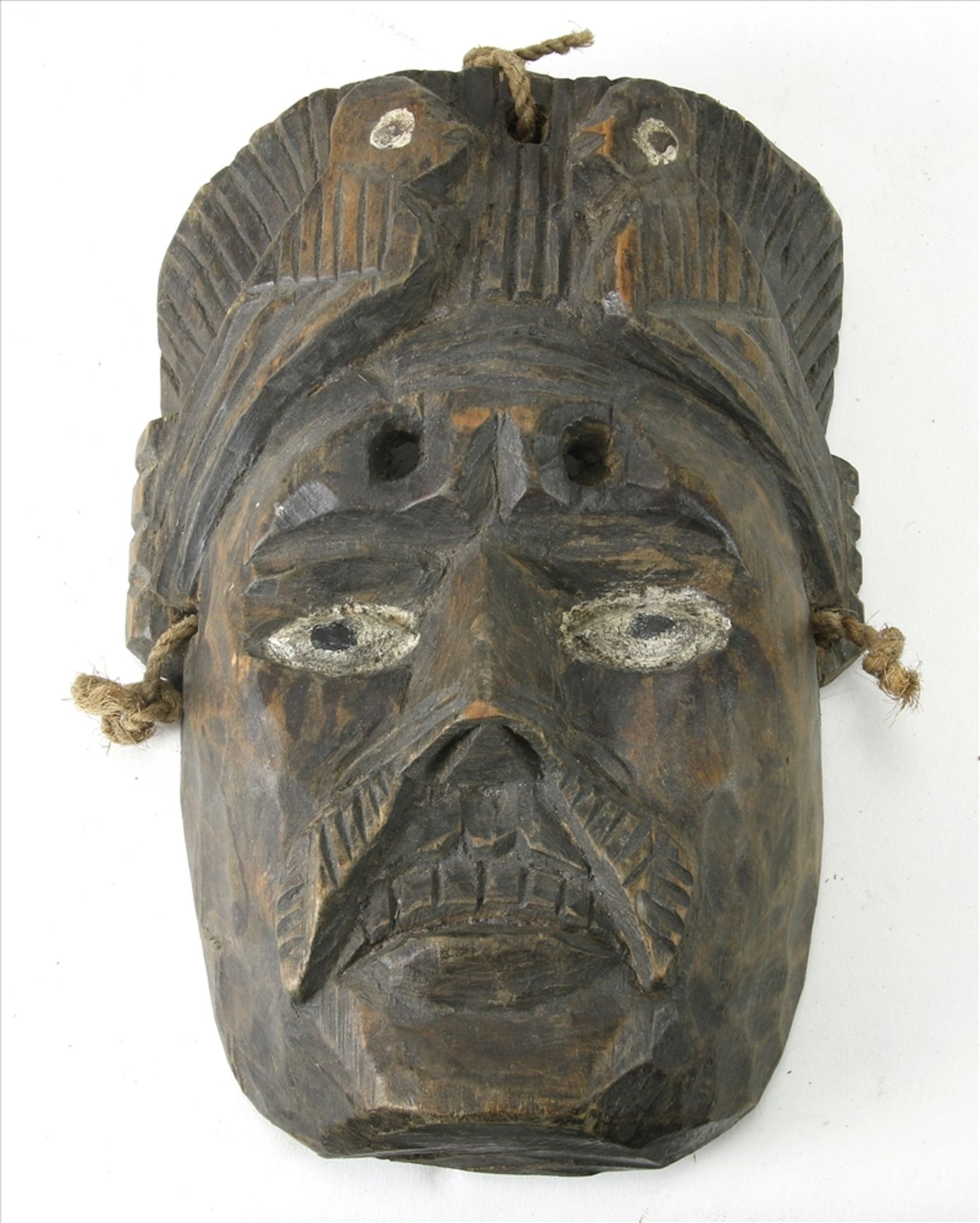 Maske Wohl Kongo um 1900. Hartholz, teils mit Vögeln geschnitzt, die Augen staffiert. Größe ca. 24,5