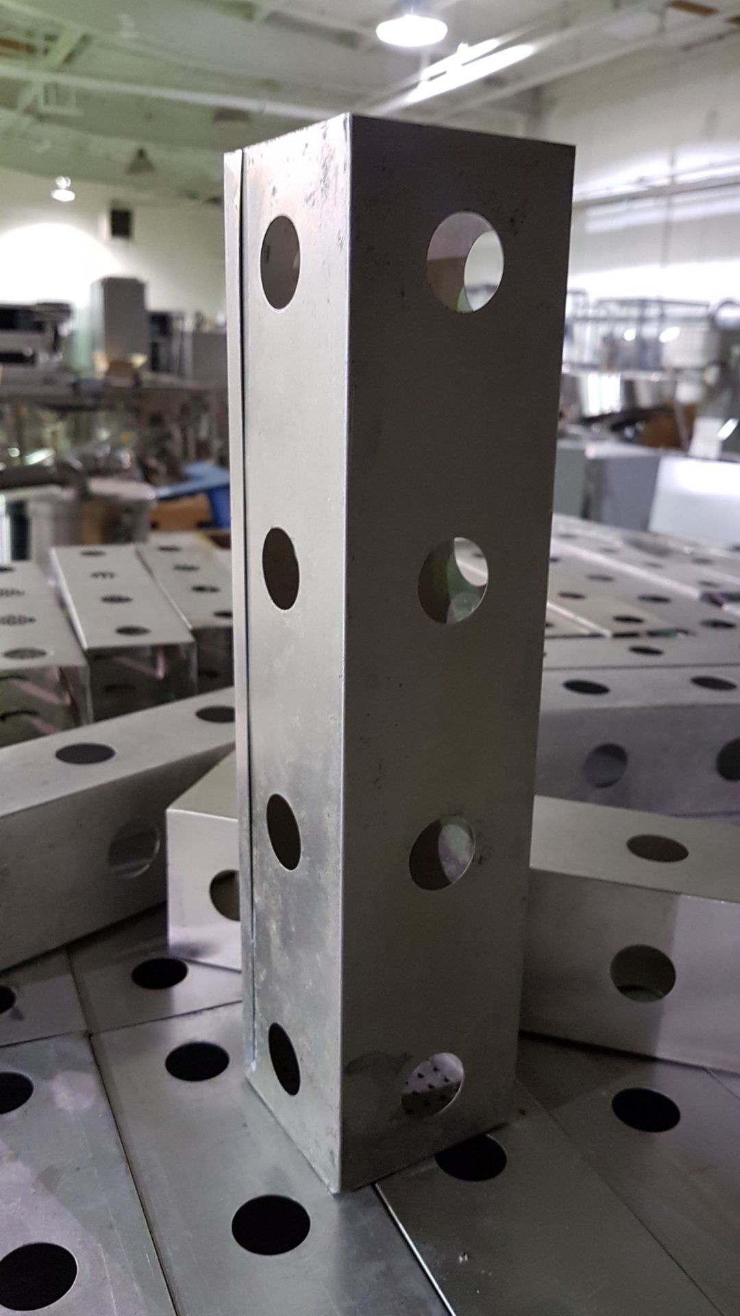 Pallet of used aluminum strainer inserts, with perforated bottoms