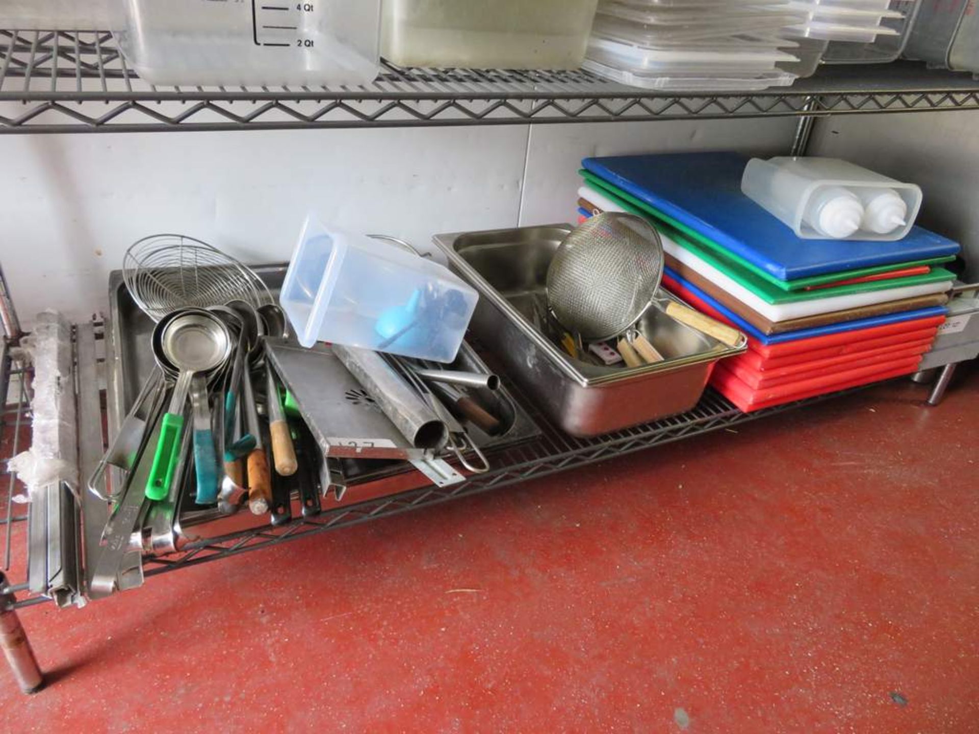 Various kitchen utensils, colour coded chopping boards and bain marie trays.