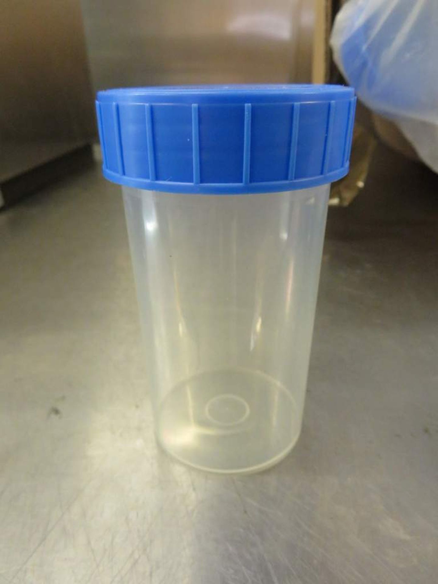 A large quantity of lidded plastic sample pots.