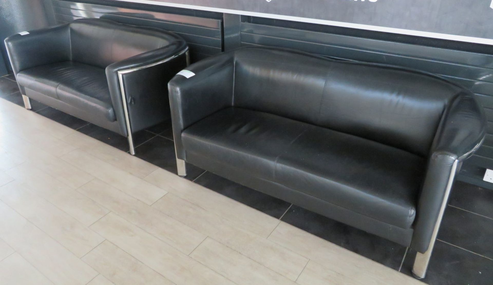 PAIR OF BLACK LEATHER EFFECT TWO-SEATER SOFAS