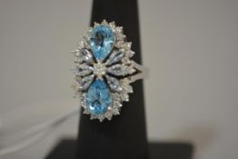 A striking blue topaz and diamond dress ring, mounted with a pair of pear-cut topaz amidst a setting