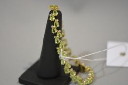 A peridot and diamond bracelet, set with pear-cut peridots and diamond points, mounted in 14ct