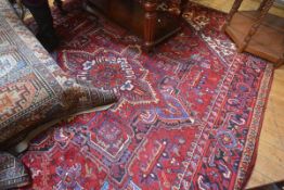 A Mashed carpet, the central diamond shaped panel with allover stylised flower and leaf design,