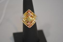 A yellow sapphire and diamond plaque ring, the lozenge shaped palque set with concentric bands of