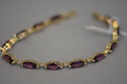 An amethyst link bracelet, set with diamond point spacers and mounted in 14ct yellow gold. 18cm