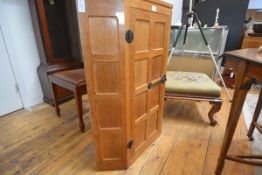 A Robert "Mouseman" Thompson oak hanging corner cupboard, c. 1970, with cut-off corners and single