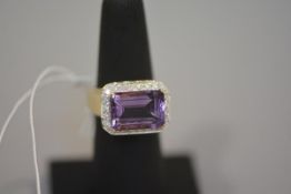 An amethyst and diamond dress ring, the large emerald-cut amethyst within a band of round