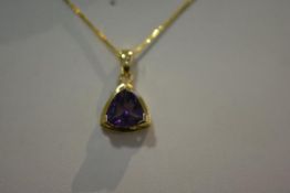 An amethyst pendant, the trillion-cut amethyst claw-set in yellow metal stamped 585, on a
