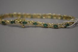 An emerald and diamond link bracelet, with oval-cut emeralds spaced by diamond points, mounted in