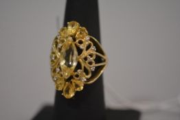 A citrine and diamond dress ring, centred by a large marquise-cut citrine within an openwork setting