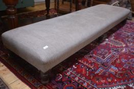 A large fireside stool in period style, raised on turned mahogany legs. 29cm by 213cm by 61cm