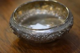 A Burmese 950 standard silver bowl, repousse with cartouches depicting figures at prayer, at work