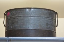 A large galvanised circular twin-handled planter. 32cm by 55cm diameter