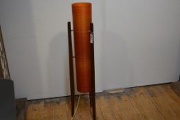A 1960's floor standing rocket lamp, raised on three tapering teak legs and with orange fibreglass
