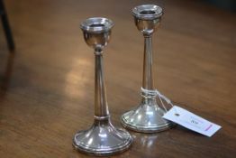 A pair of George V silver candlesticks, Birmingham 1921, with semi-spherical cups on tapering