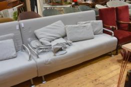 An Italian contemporary sofa bed by BBB Emmebonacina, in grey, with fold out seat and raised on