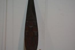 A West African carved wooden dance paddle, the leaf-shaped blade carved with lizards and geometric
