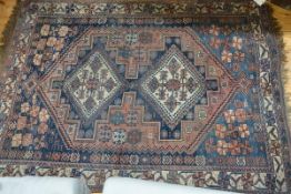 A Caucasian rug, with twin diamond medallions within a multiple stylised floral and running dog