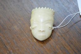 An African carved ivory mask pendant, probably Pende, Congo/Gabon, with multi-point coiffure,