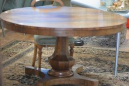 A William IV rosewood tilt-top dining table, the circular top on a massive faceted baluster