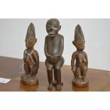 Two Nigerian carved wooden standing female figures, each with tall headdress, both decorated with