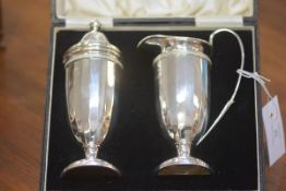 A George V cased silver sifter and cream set, Birmingham 1930, in the Art Deco taste, each of