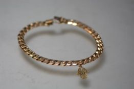 An Italian yellow metal curblink bracelet, stamped 375, suspending a small charm. 21 grams